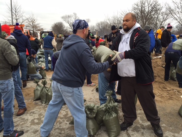 Volunteers load sand bags for the River Des Peres Levee