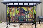 Bus shelter art with a Black woman in the center holding a globe, flowers around her and two Black children on either side of her