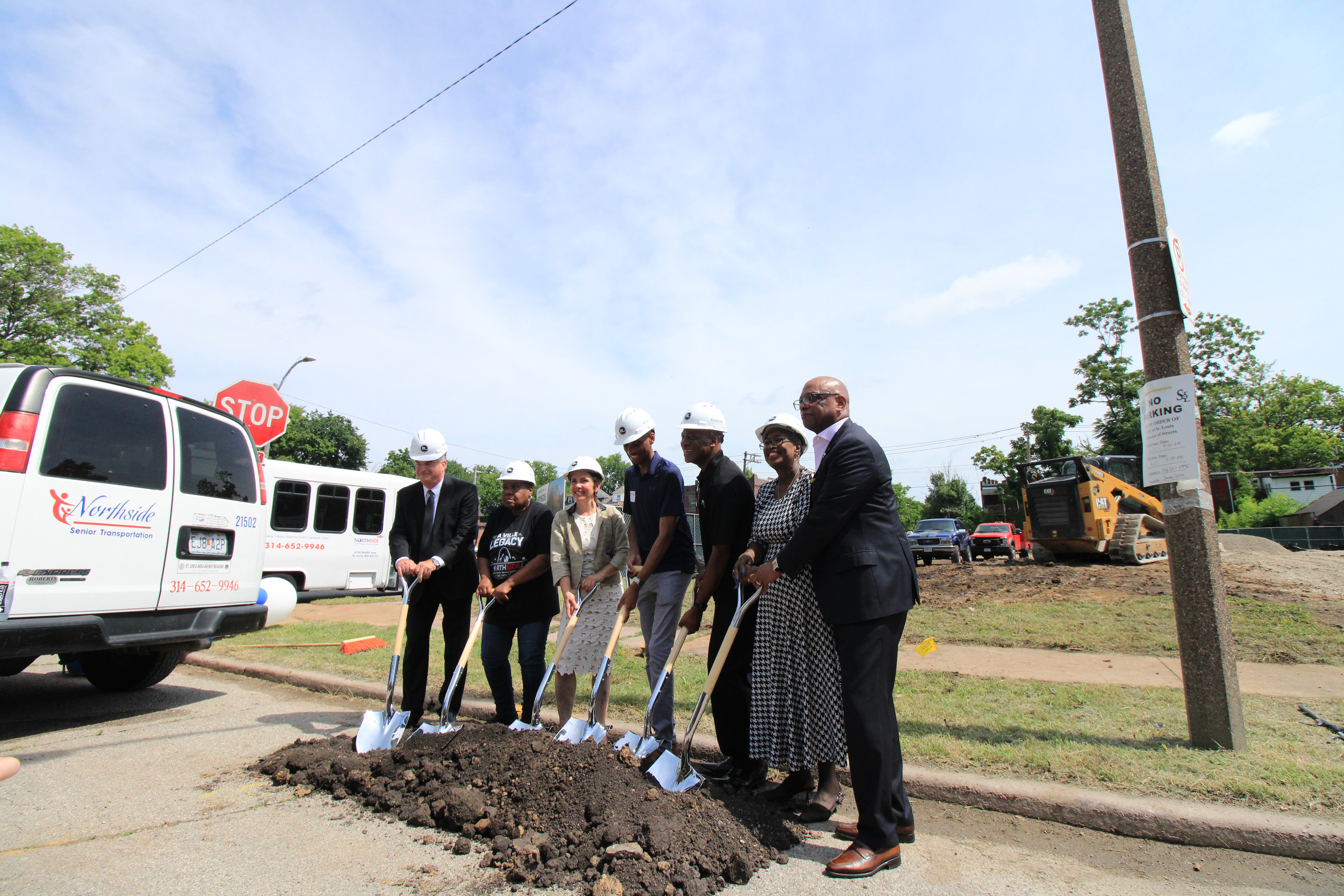 Community leaders shovel into a pile of dirt for the official groundbreaking ceremony