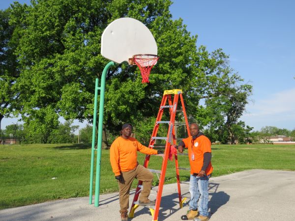City of St. Louis Parks Department workers installing basketball net at Sherman Park
