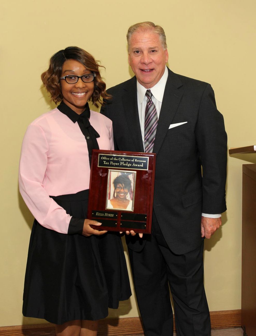 Kelia Hykes receives the Taxpayer Pledge Award from Collector Greg F.X. Daly