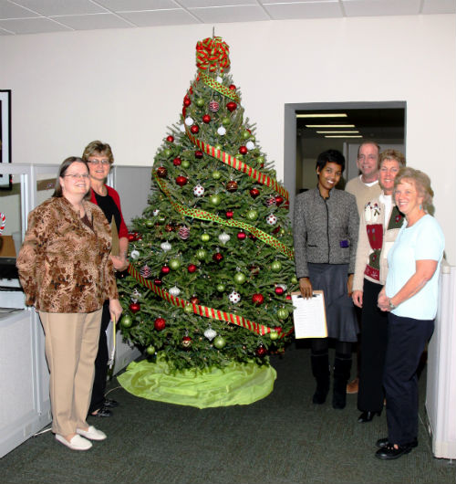 COR employees and contest judges pose by the The Grinch entry in the 2012 Tree Decorating Contest.